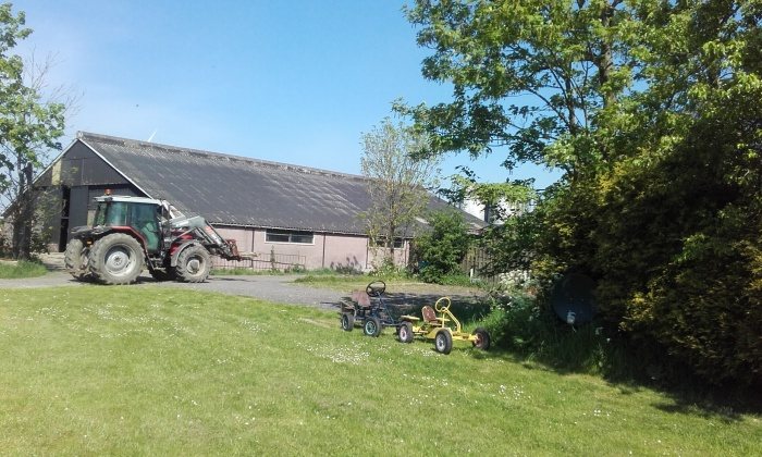 De boerderij van De Slypstien met de trekker voor de schuur
